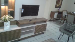 a living room with a flat screen television on a cabinet at Apto próximo ao Centro de Eventos e OAB-CE in Fortaleza