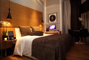 a bedroom with a large bed with a wooden headboard at Browns Downtown Hotel in Lisbon