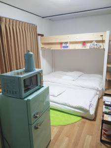 a bedroom with a bunk bed and a microwave on a cabinet at M's Kanazawa in Kanazawa