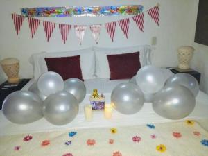 Un mucchio di palloncini su un letto con le candele di La Loma Hotel Barichara a Barichara