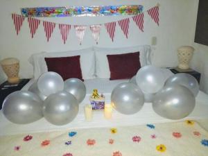 a bunch of balloons on a bed with candles at La Loma Hotel Barichara in Barichara