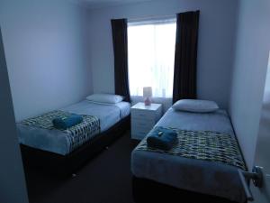 1 dormitorio con 2 camas y ventana en Merimbula Lake Apartments, en Merimbula