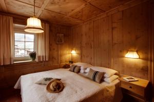 a bedroom with a bed with two hats on it at Berghotel Ladinia in Corvara in Badia