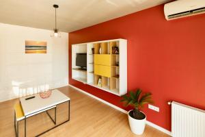 - un salon avec un mur rouge et une table dans l'établissement Apartament Aty, à Mamaia Nord – Năvodari