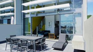 City Fringe Apartment with Sky Tower and City Views في أوكلاند: فناء على طاولة وكراسي في مبنى