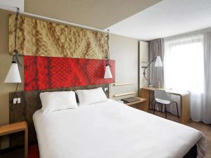 Pokój hotelowy z dużym białym łóżkiem z 2 poduszkami w obiekcie ibis Marne La Vallee Champs-sur-Marne w mieście Champs-Sur-Marne