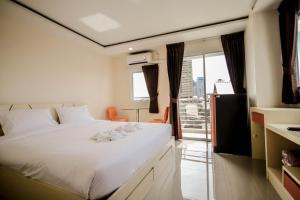a bedroom with a large white bed and a balcony at The Cosy River in Bangkok