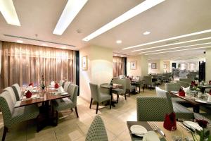 a dining room with tables and chairs in a restaurant at City Seasons Al Hamra Hotel in Abu Dhabi