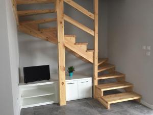 a wooden staircase in a room with a tv at ZMIANA KLIMATU in Karwia