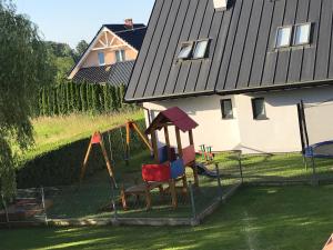 a playground in a yard next to a house at ZMIANA KLIMATU in Karwia