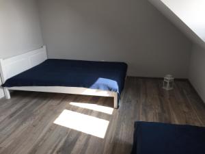 małą sypialnię z łóżkiem i drewnianą podłogą w obiekcie ZMIANA KLIMATU w Karwii