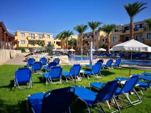 um grupo de cadeiras em frente a uma piscina em Pagona Holiday Apartments em Pafos