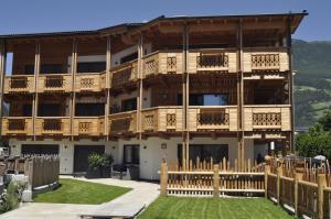 an apartment building with balconies and a yard at Chalet Schwarzenstein in Campo Tures