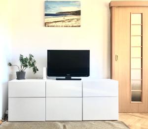 a white entertainment center with a television on top of it at Sopot 35 in Sopot
