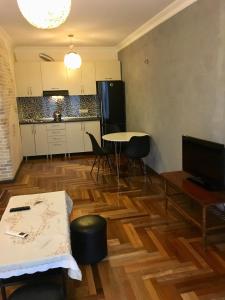 Il comprend un salon avec une table et une cuisine. dans l'établissement Apartment Gamarjoba Batumi, à Batoumi