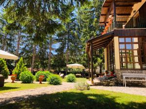 una casa con gente sentada en un banco en un patio en Villa dei Pini, en Pescasseroli