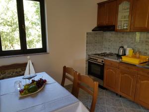 a kitchen with a table with a bowl of fruit on it at Vila Kajče in Omišalj