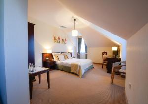 a bedroom with a bed and a table in a room at Hotel Nowodwory in Ciechanowiec