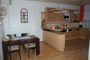 eine Küche mit einem Tisch, Stühlen und einer Theke in der Unterkunft Apartmán Brašov, Týn nad Vltavou in Týn nad Vltavou