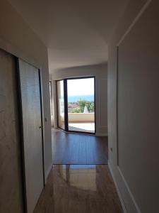 un couloir vide avec une grande fenêtre dans une maison dans l'établissement Apartments Stefanov in Byala, à Byala