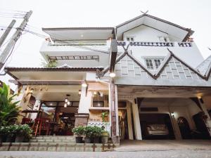 a white house with stairs and potted plants at Rendezvous Oldtown Chiangmai in Chiang Mai