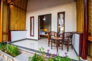 a room with a table and chairs and a bedroom at Meket Bungalows in Nusa Penida