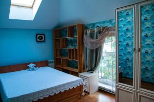 a blue bedroom with a bed and a window at Дом вблизи моря in Odesa