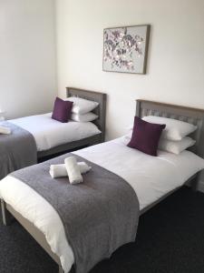 a room with two beds with purple and white pillows at Church House in Great Yarmouth