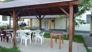 a wooden gazebo with tables and chairs in a yard at Bridgehaus in Balatonfüred