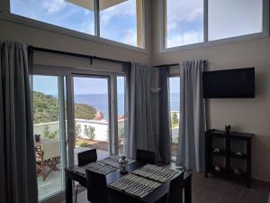 une salle à manger avec une table et une vue sur l'océan dans l'établissement Above the Sea Apartments, à Skala Marion