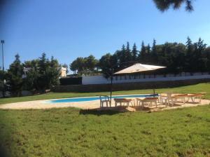 a group of tables and an umbrella next to a pool at Ktima Nafsika - First-floor luxury apartment in majestic estate in Rozaíika