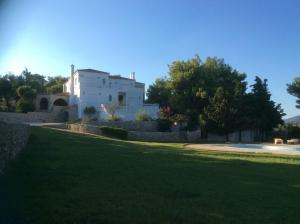 a white house with a yard with a green lawn at Ktima Nafsika - First-floor luxury apartment in majestic estate in Rozaíika
