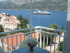 un balcón con un crucero en el agua en Apartments Baric, en Korčula