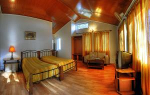 um quarto com 2 camas e uma televisão de ecrã plano em Hotel Clouds End Villa Cottages em Dharamshala