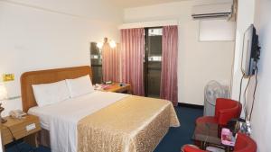 una camera d'albergo con un letto e una televisione di Chian Huei Business Hotel a Taipei