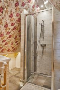a shower stall in a bathroom with floral wallpaper at Gorce Oasis in Szlembark