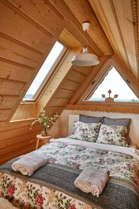 a bedroom with a large bed in a attic at Gorce Oasis in Szlembark