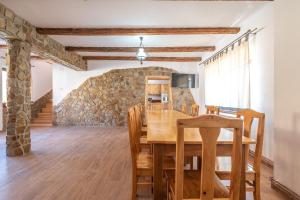 a dining room with a table and a stone wall at La Tusa Dusa in Ocolişu Mic