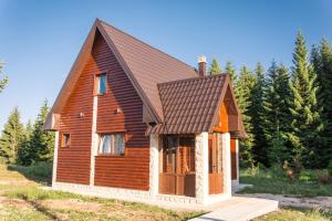 uma pequena casa de madeira com telhado castanho em Wood Inn em Žabljak