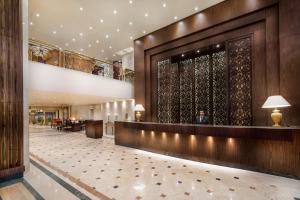 a lobby of a hotel with a man sitting at a counter at Pyramisa Suites Hotel Cairo in Cairo