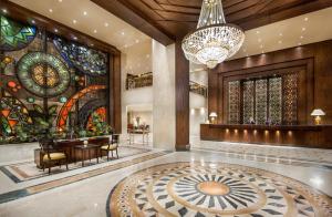a lobby with a chandelier and stained glass windows at Pyramisa Suites Hotel Cairo in Cairo