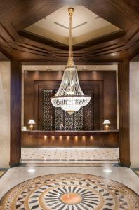a large chandelier in a lobby with a table at Pyramisa Suites Hotel Cairo in Cairo