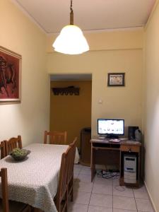 a dining room with a table and a computer on a desk at Anna Apartment in Kypseli in Athens