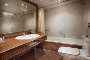 a bathroom with a sink and a toilet and a tub at Pyramisa Suites Hotel Cairo in Cairo