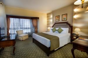 a hotel room with a bed and a chair at Pyramisa Suites Hotel Cairo in Cairo