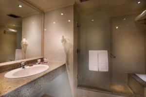 a bathroom with a sink and a shower with a mirror at Pyramisa Suites Hotel Cairo in Cairo