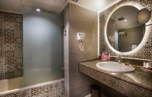a bathroom with a sink and a mirror at Pyramisa Suites Hotel Cairo in Cairo