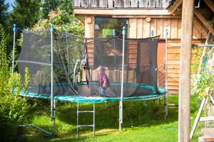 ein Kind steht auf einem Trampolin im Hof in der Unterkunft Appartements Tauernzauber in Schladming