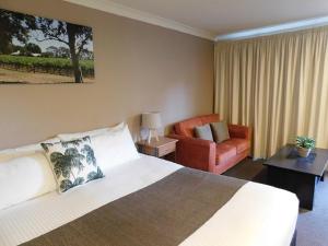 Habitación de hotel con cama y silla en Alexander Cameron Suites en Penola