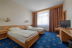 a hotel room with two beds and a television at Hotel Kronprinz Garni in Minden